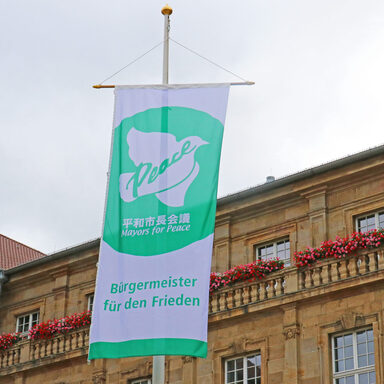 Grün-weiße Flagge des Städtebündnisses vorm Kasseler Rathaus
