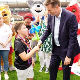 Oberbürgermeister Schoeller gibt einem Jungen die Hand