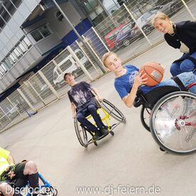 Mehrere Rollstuhlfahrer, die Basketball spielen