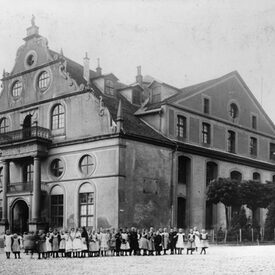 Schwarz-Weiß-Foto des Ottoneums von 1927 mit Kindergruppe davor.