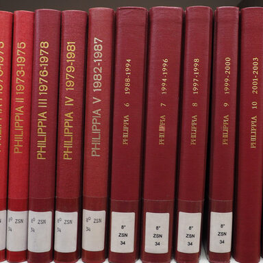 Mehrere Ausgaben der Museumszeitschrift Philippia in roten Einbänden mit goldener Schrift stehen im Regal.