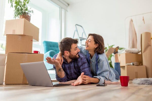 Paar mit Laptop in neuer Wohnung